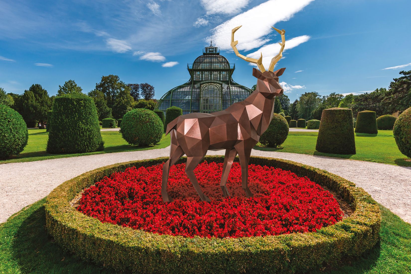 Deer in a Garden in the Middle of a Bed of Red Flowers