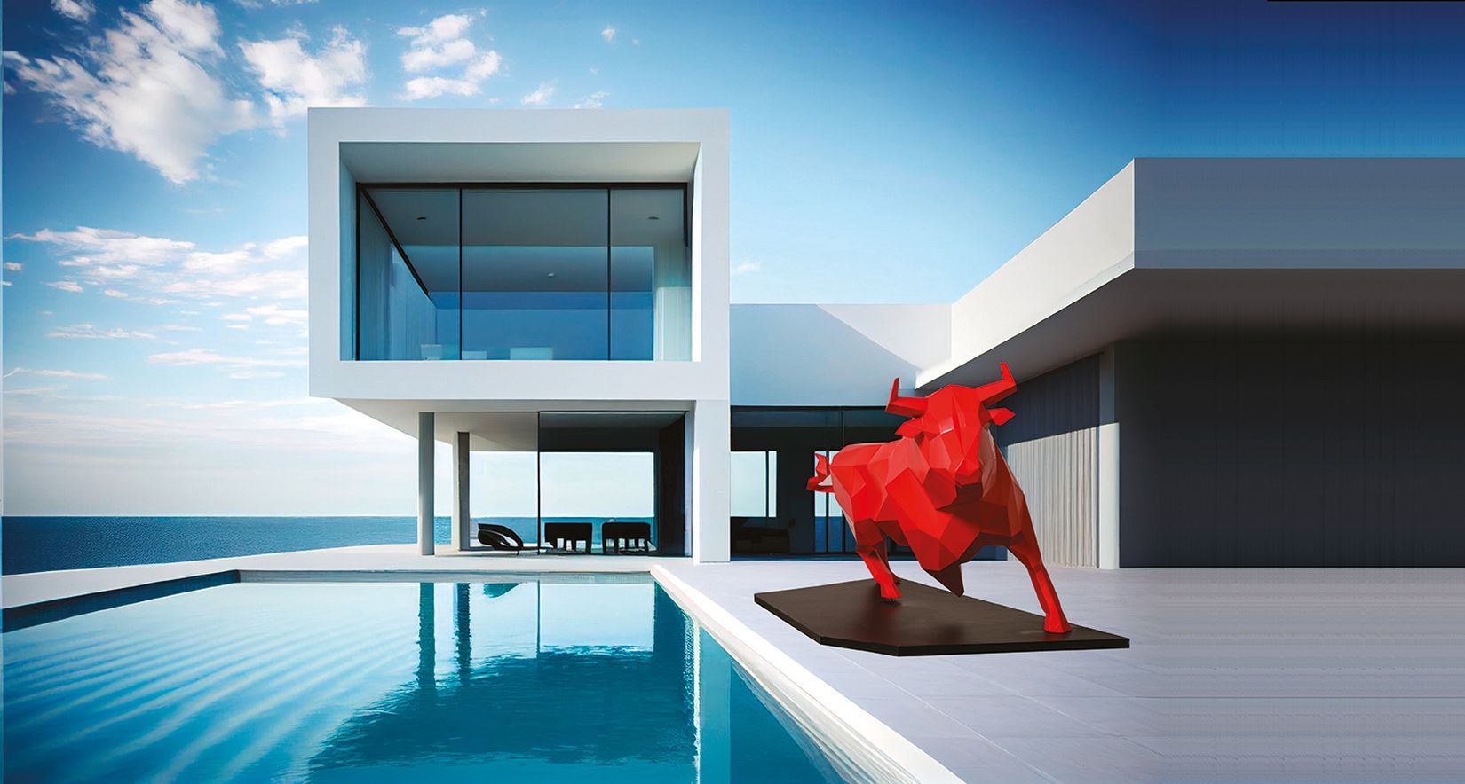 Escultura de un toro al borde de una piscina en una villa de arquitecto junto al mar
